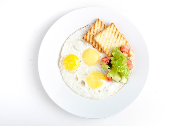 Uova fritte con toast fritto e insalata di cetrioli freschi e pomodori alle erbe