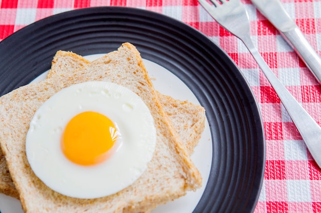 Uova fritte e pane tostato di cereali integrali serviti a tavola