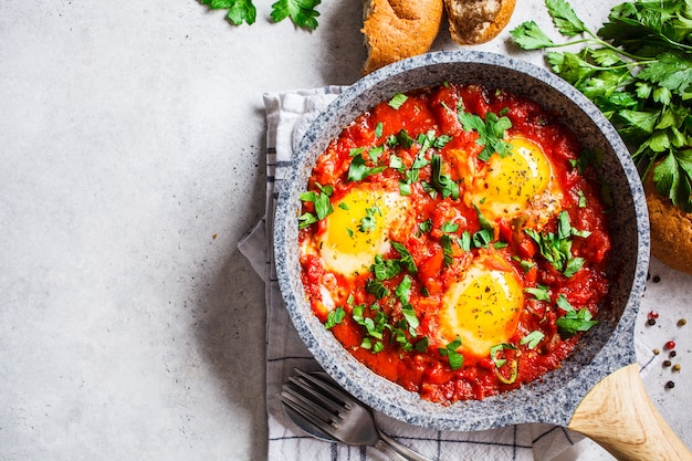 Uova fritte in salsa di pomodoro con erbe