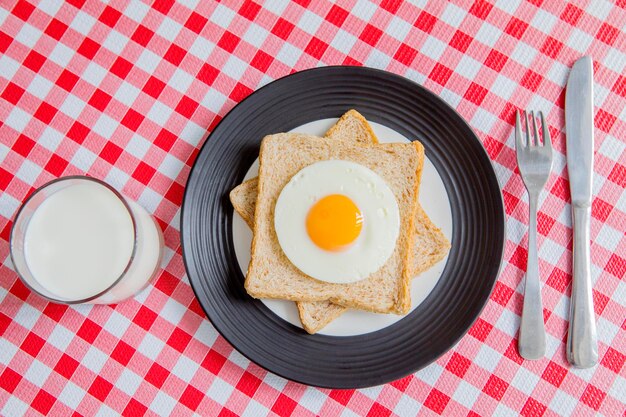uova fritte su pane tostato integrale con un bicchiere di latte