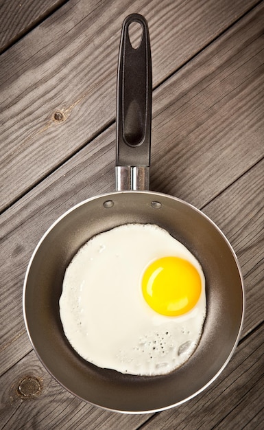 Uova fritte su un tavolo di legno, colazione