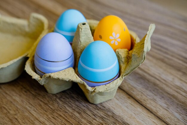 Uova in una scatola di cartone su un tavolo di legno close-up Buona Pasqua