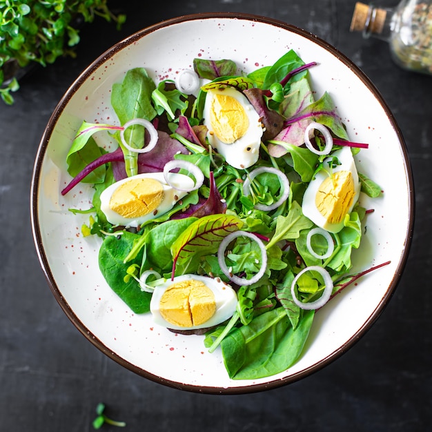 Uova insalata di verdure fresche foglie verdi mescolare spinaci rucola lattuga uova bollite alimenti biologici