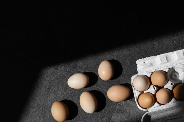 Uova marroni in scatola di cartone su sfondo scuro