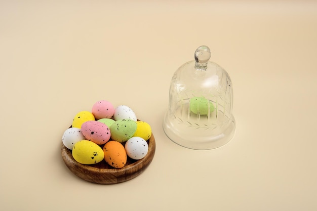 Uova multicolori di Pasqua su un supporto in legno con coperchio in vetro