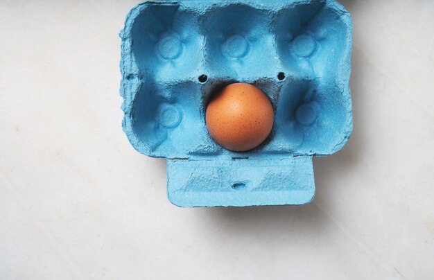 Uova nella scatola delle uova blu. Concetto di cibo minimalista. Lay piatto. Vista dall'alto.