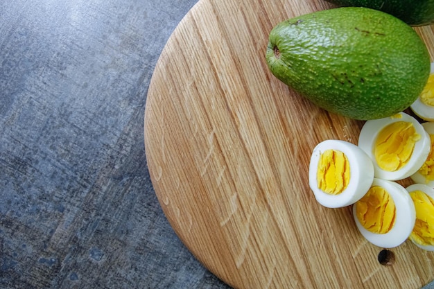 uova sode con avocado su una tavola di legno