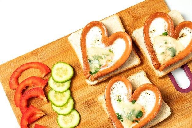 Uova strapazzate in salsiccia, salsiccia a forma di cuore, cuore, colazione, vista dall'alto sulla lavagna