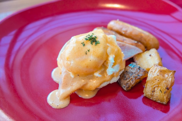 Uovo alla Benedict in un piatto rosso