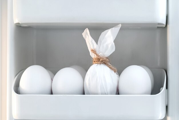 Uovo decorato come coniglio di coniglietto di Pasqua tra le altre uova in frigorifero. Caccia di Pasqua. Buona Pasqua