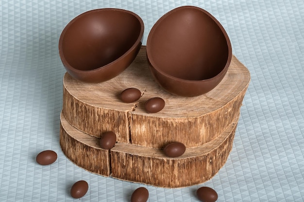 Uovo di cioccolato su una tavola di legno rustica Piccole uova di cioccolato in una metà dell'uovo di cioccolato pasquale