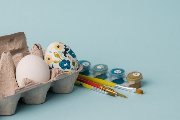 Uovo di gallina dipinto in motivi floreali. Artigianato fai-da-te per le vacanze di Pasqua con i bambini. Decorazione botanica