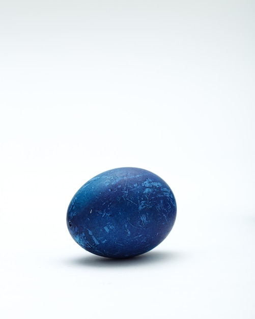 Uovo di Pasqua blu decorato su fondo bianco