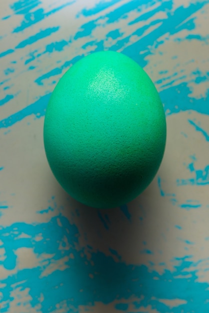 Uovo di Pasqua ciano sul blu misero con graffi