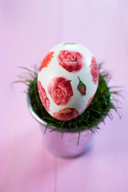 Uovo di Pasqua decorato con rose su una pianta in vaso