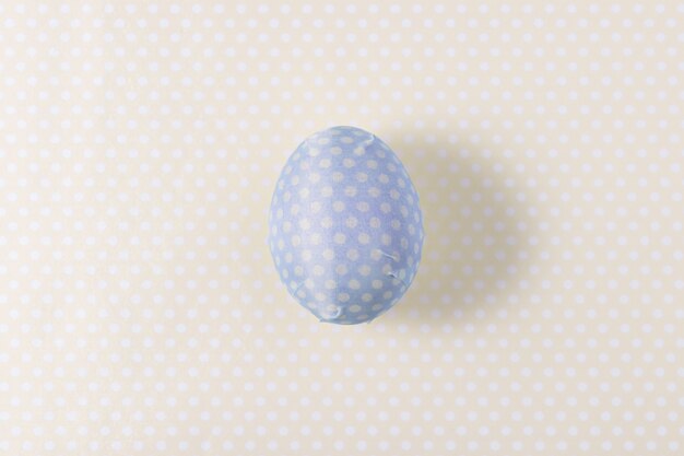 Uovo di Pasqua decorato con tovagliolo di carta blu.