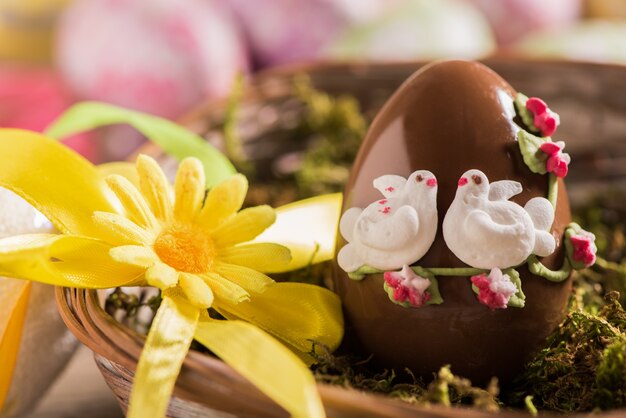 Uovo di Pasqua di cioccolato decorato sulla tavola di legno