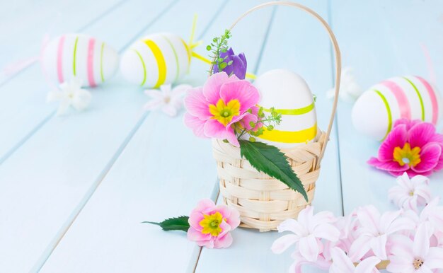 Uovo di Pasqua in un cesto decorato con fiori