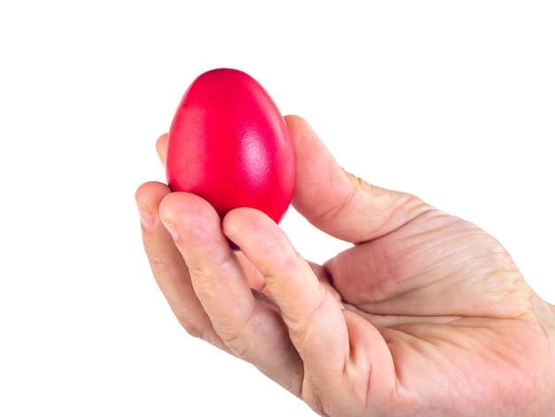 Uovo di Pasqua rosso in mano della donna isolato su bianco