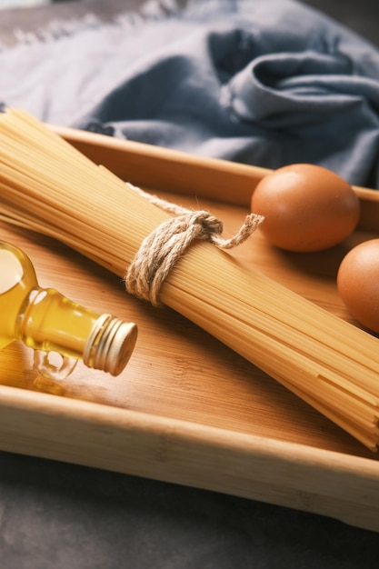 Uovo di spaghetti lunghi gialli e olio sulla tavola