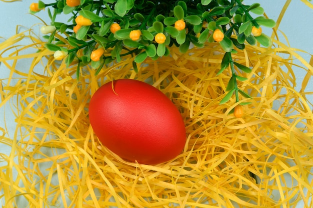 Uovo dipinto di rosso su giallo paglierino, che simboleggia la Pasqua.