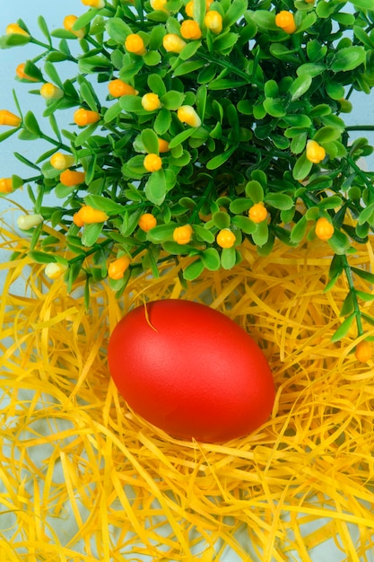 Uovo dipinto di rosso su giallo paglierino, che simboleggia la Pasqua.