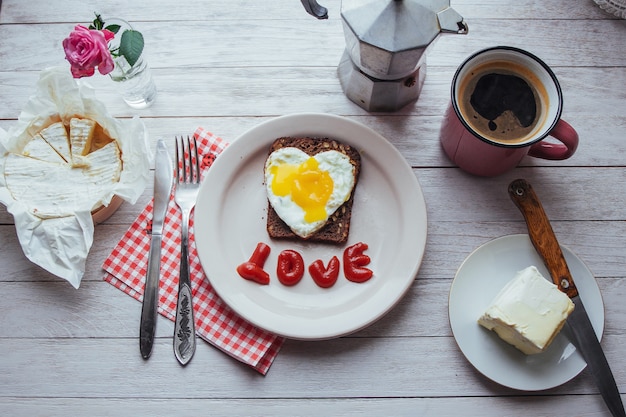 Uovo fritto con brie di formaggio e ketchup. Gustoso caffè profumato al mattino