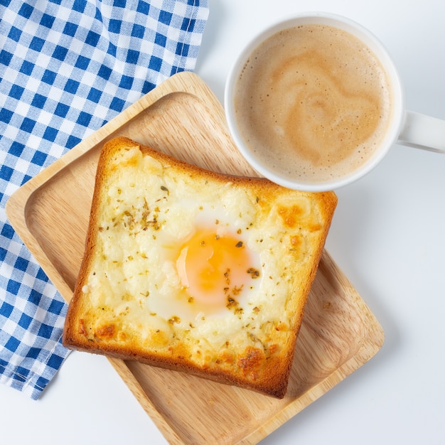 Uovo fritto su pane tostato e tazza di caffè per la colazione.