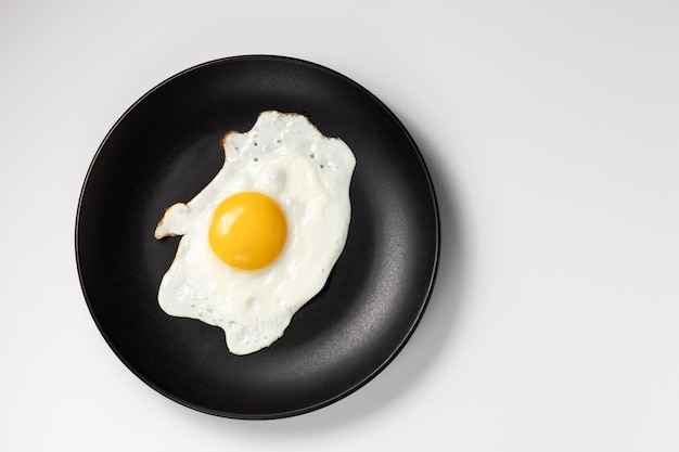 Uovo fritto su una banda nera. Isolato su sfondo bianco