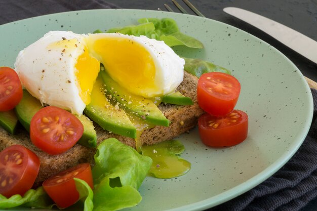 Uovo in camicia su pane sano con avocado.