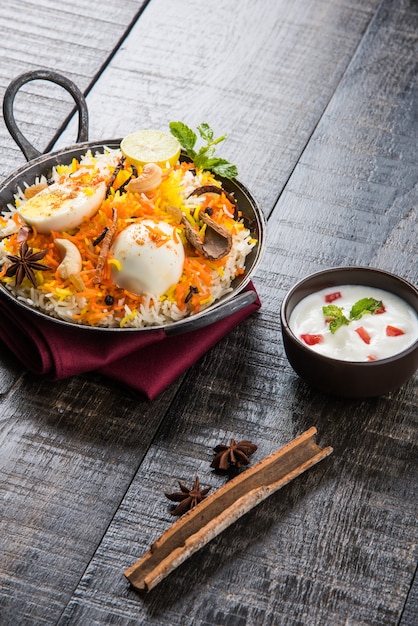 Uovo indiano Biryani o riso anda servito in kadhai o kadai con salsa allo yogurt, messa a fuoco selettiva