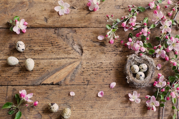 Uovo nel nido con fiori rosa