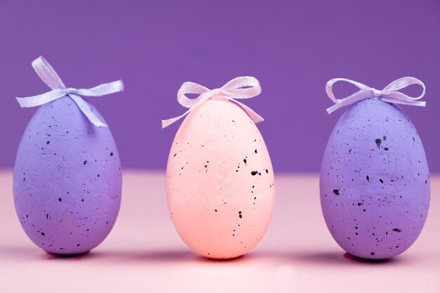 Uovo rosa con decorazioni su una superficie viola