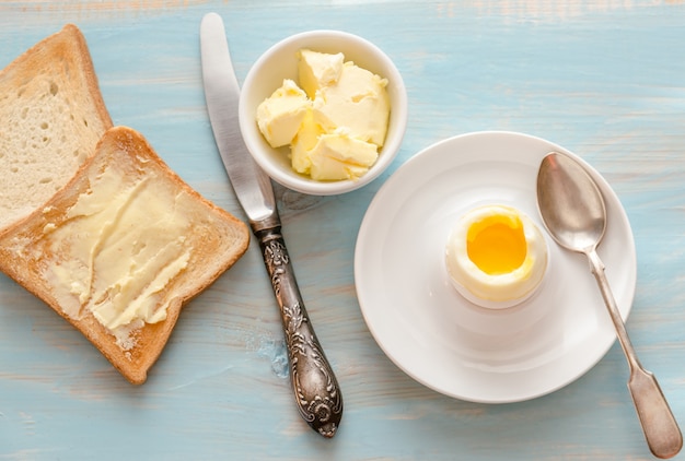 Uovo sodo con toast croccanti sul tavolo di legno