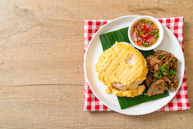 uovo su riso ricoperto con carne di maiale alla griglia e salsa piccante - stile di cibo asiatico