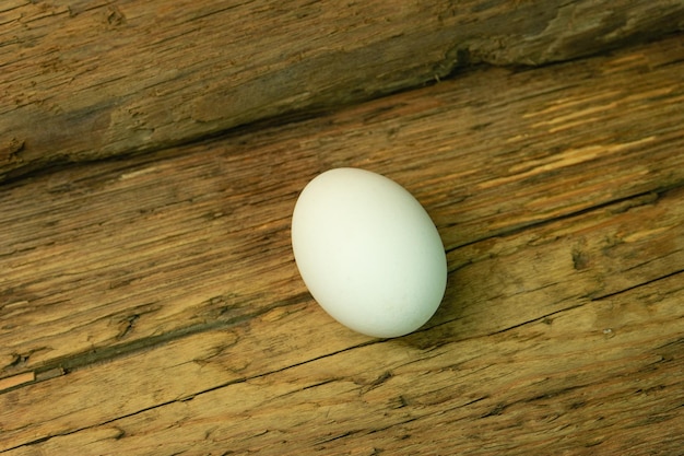 Uovo sullo sfondo di un vecchio tavolo di legno di quercia