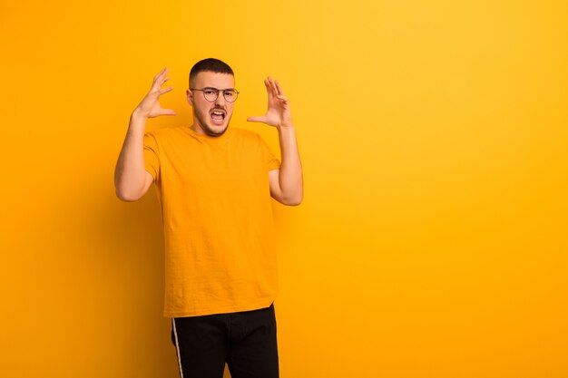 urlando con le mani in alto, sentendosi furioso, frustrato, stressato e turbato