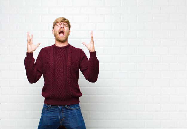 urlando furiosamente, sentendosi stressato e infastidito con le mani in alto che dicevano perché io