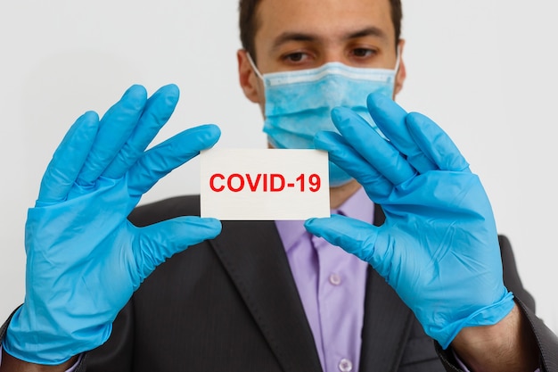 Usa i filtri di protezione contro il coronavirus! Uomo d'affari in maschera igienica e guanti, 2019-nCoV, epidemia di influenza. isolato