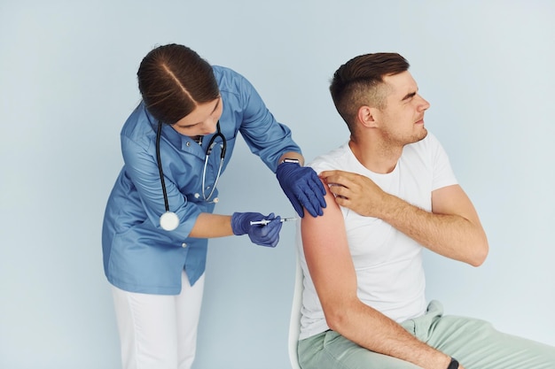 Usando la siringa Medico in uniforme che effettua la vaccinazione al paziente