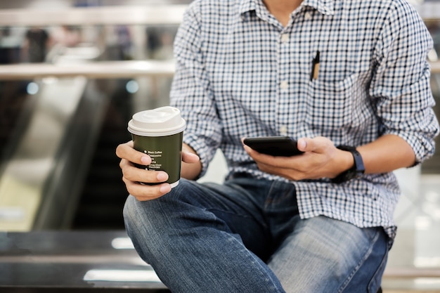 usando lo smartphone tra un caffè caldo e l'altro.