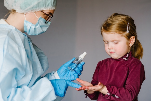 Uso medico Disinfettante per le mani gel alcolico strofinare le mani pulite bambino, prevenzione igiene dell'epidemia di coronavirus. Bambino che utilizza una bottiglia di sapone antibatterico disinfettante.