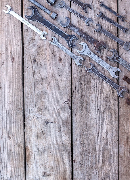 Utensili arrugginiti con chiave in metallo che giacciono su un tavolo di legno nero Martello scalpello seghetto chiave in metalloCopia spazio