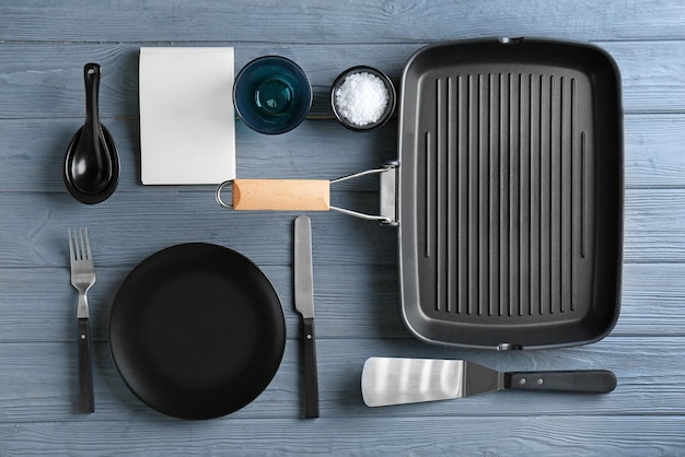 Utensili da cucina e taccuino aperto su fondo di legno