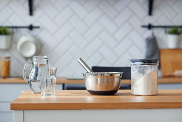 Utensili da cucina per la cottura fatta in casa su un tavolo da cucina in legno chiaro