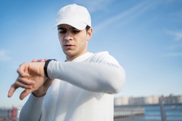 Utilizza un orologio fitness sulla mano di un atleta corridore maschio misura il polso