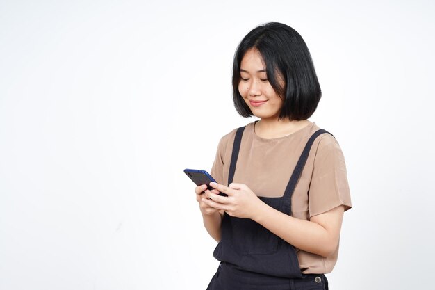 Utilizzando Smartphone e sorridente di bella donna asiatica isolata su sfondo bianco