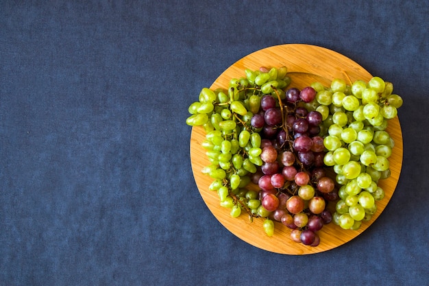 Uva d'autunno sulla tavola blu, raccolta di frutta di stagione