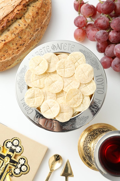 Uva di tazza di pane e croce su libro su sfondo bianco vista superiore