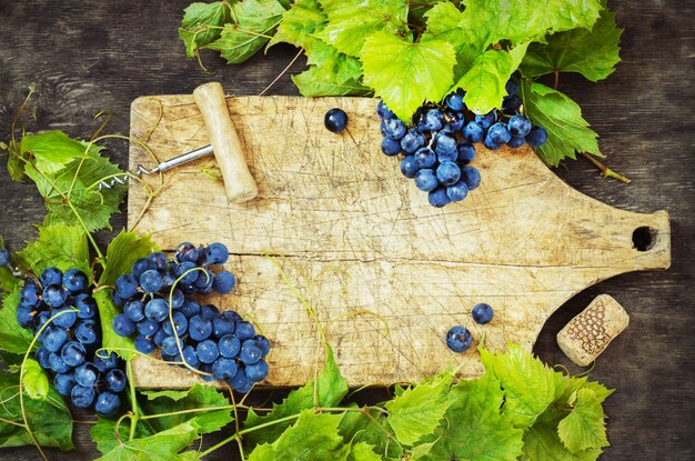 Uva e bordo anziano su un fondo di legno